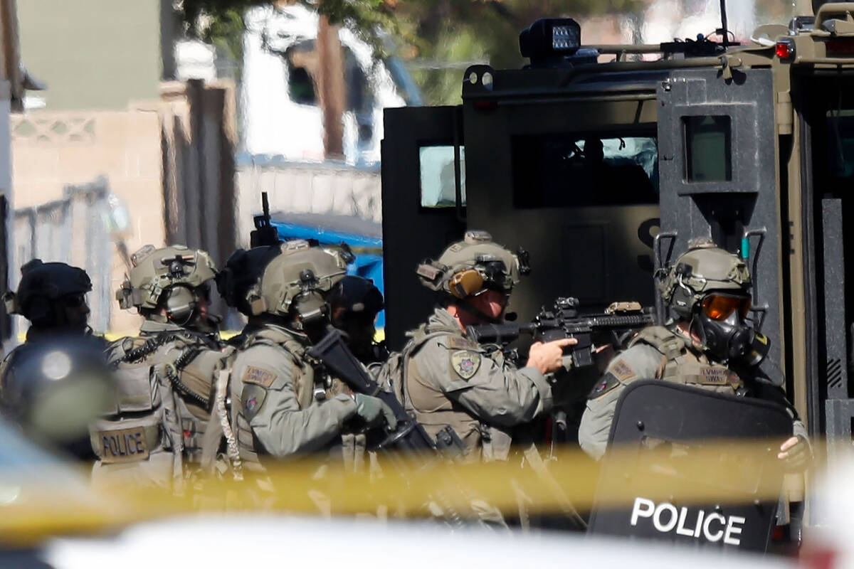 Members of the SWAT team gather around a house in the 300 block of South 11th Street, Tuesday, ...