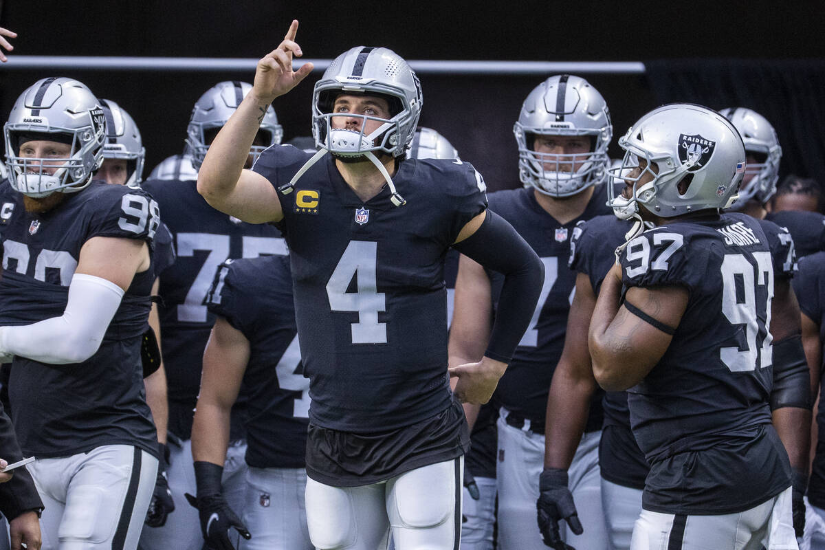 Raiders quarterback Derek Carr (4) points to the heavens when entering the field with teammates ...