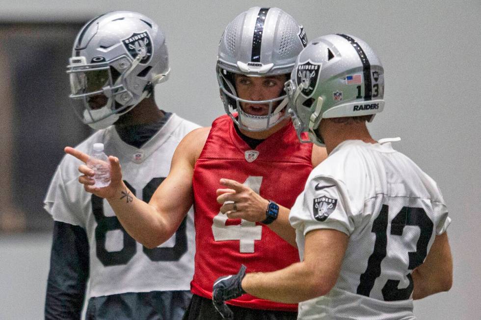 Raiders quarterback Derek Carr (4) talks to Raiders wide receiver Hunter Renfrow (13) during pr ...