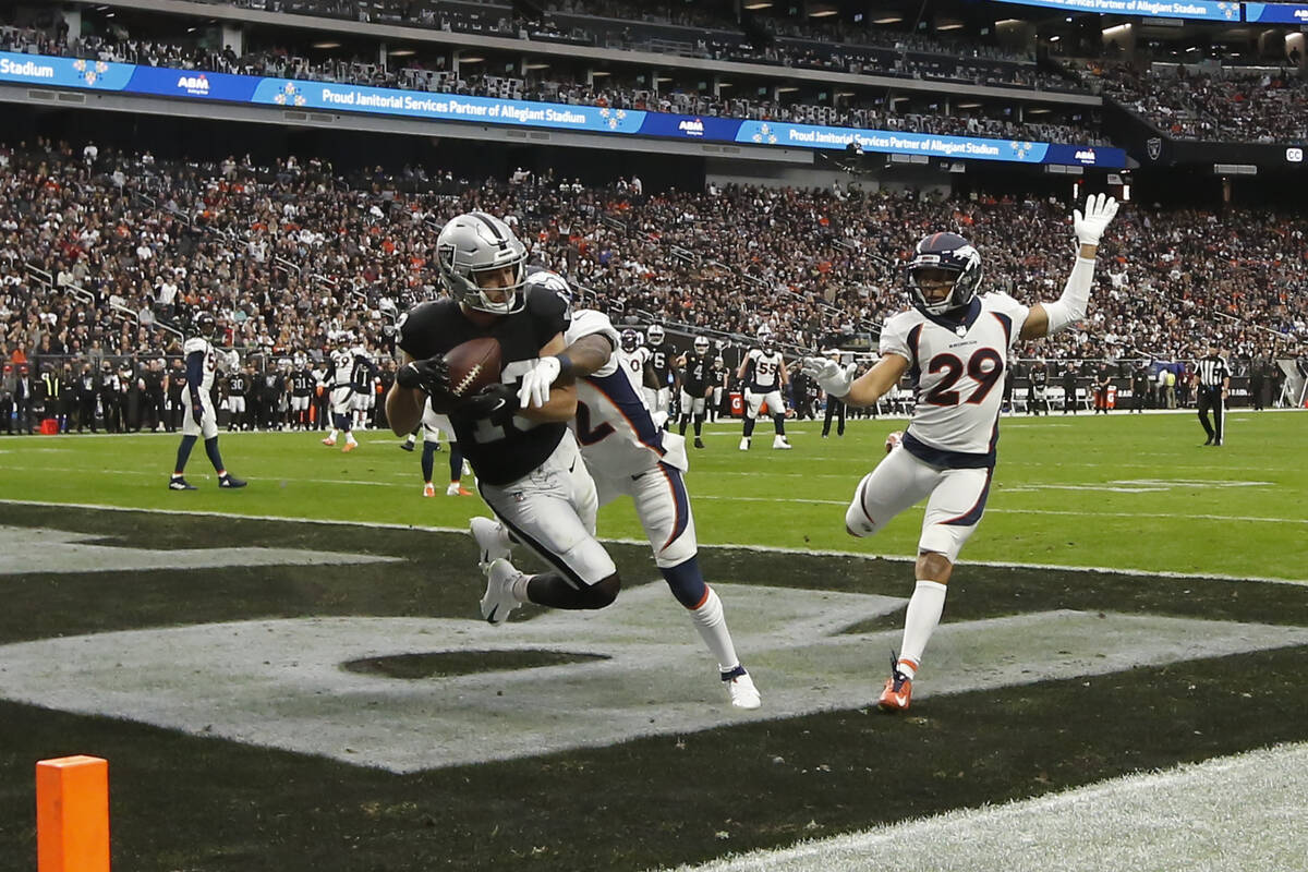 Raiders wide receiver Hunter Renfrow (13) scores a touchdown under pressure from Denver Broncos ...