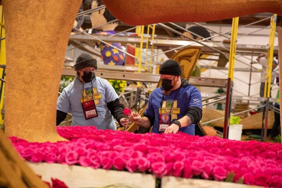 Aaron and Jennifer Bush work on the Donate Life float for Saturday's Tournament of Roses parade ...