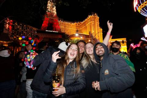People pose for a photo along the Las Vegas Strip, Friday, Dec. 31, 2021, in Las Vegas, during ...