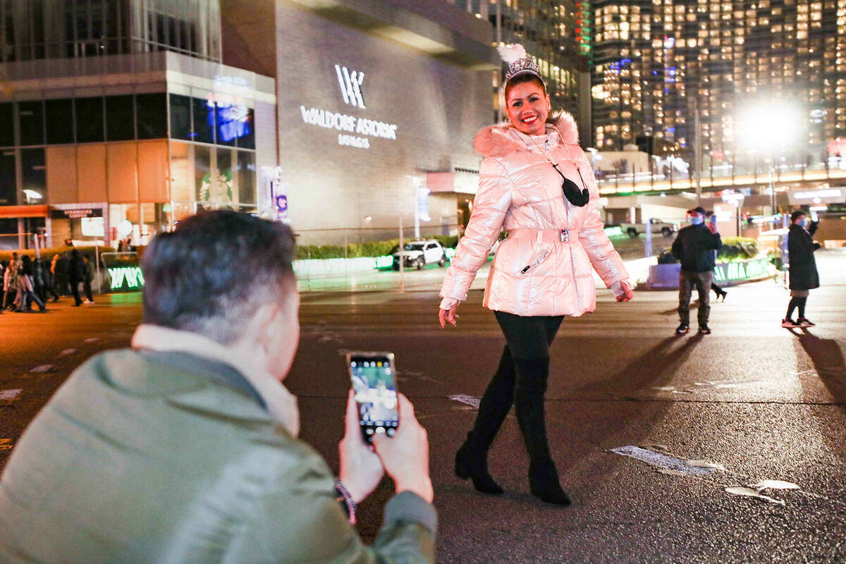 Roney Gonzalez takes a photo of his girlfriend, Riga Chow, both of Los Angeles, on the Strip on ...