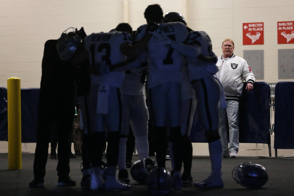 Raiders owner Mark Davis watches his player huddle before taking the field for an NFL football ...