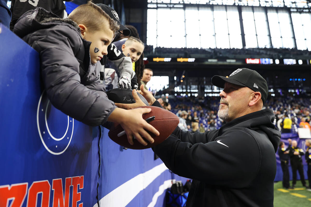 Raiders defensive coordinator Gus Bradley signs autographs for fans before the start of their N ...