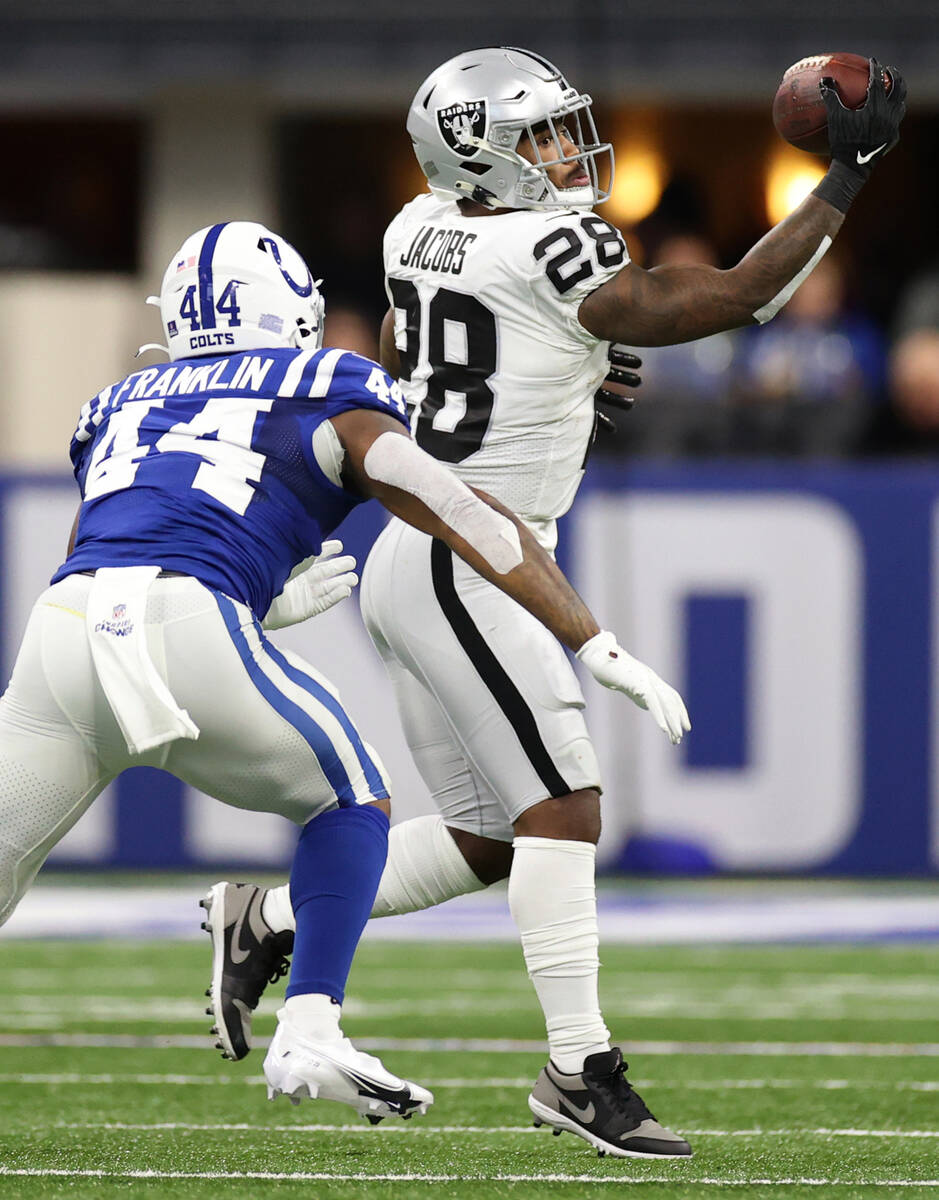 Raiders running back Josh Jacobs (28) makes a catch under pressure from Indianapolis Colts outs ...