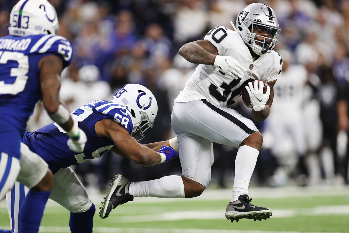 Raiders running back Jalen Richard (30) runs the ball under pressure from Indianapolis Colts mi ...