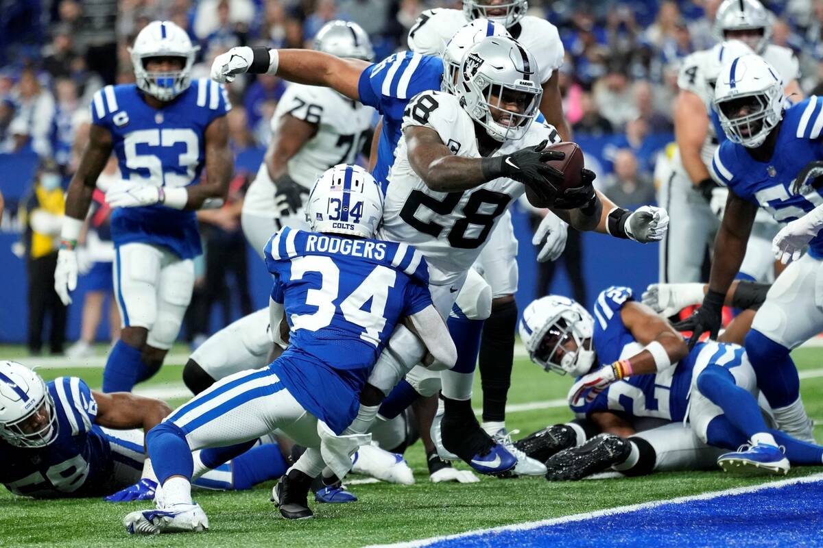 Las Vegas Raiders running back Josh Jacobs (28) scores on a 2-yard touchdown run ahead of India ...