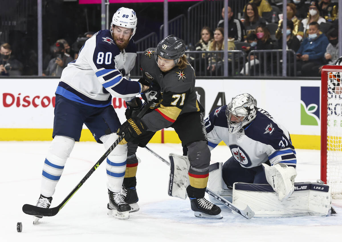 Winnipeg Jets goaltender Connor Hellebuyck (37) watches the puck as Winnipeg Jets left wing Pie ...