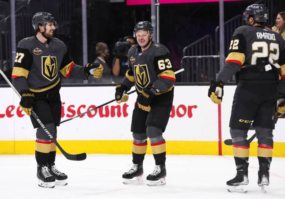 Golden Knights right wing Evgenii Dadonov (63) celebrates his goal with defenseman Shea Theodor ...