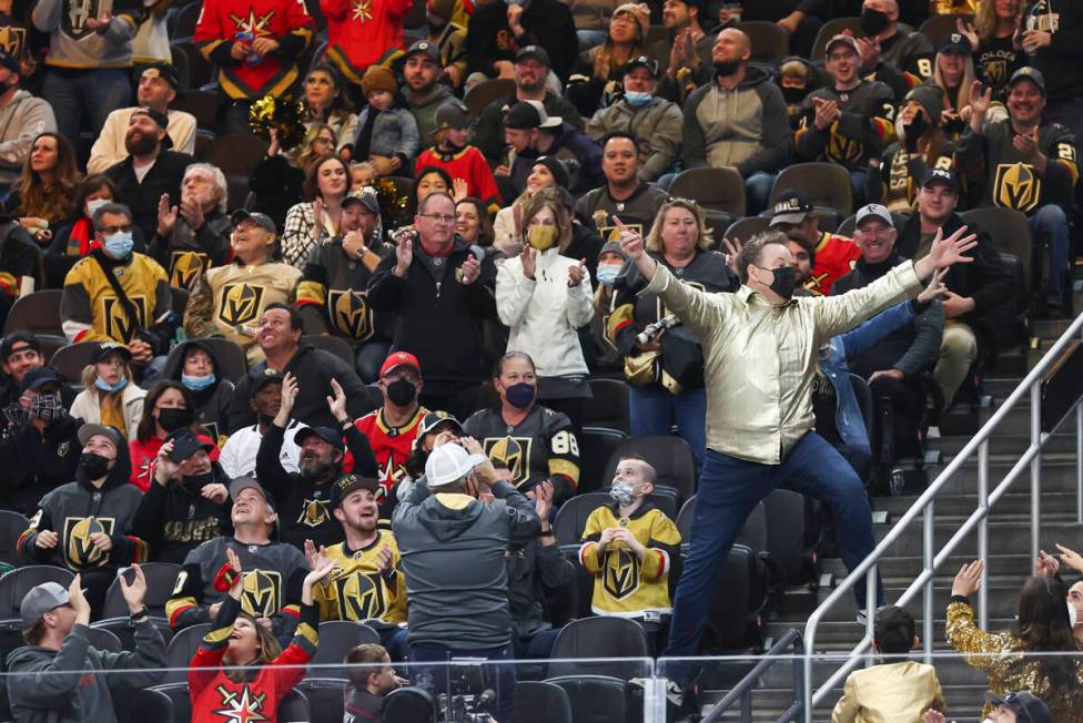 Entertainer Cameron Hughes, right, hypes up the crowd during the first period of an NHL hockey ...