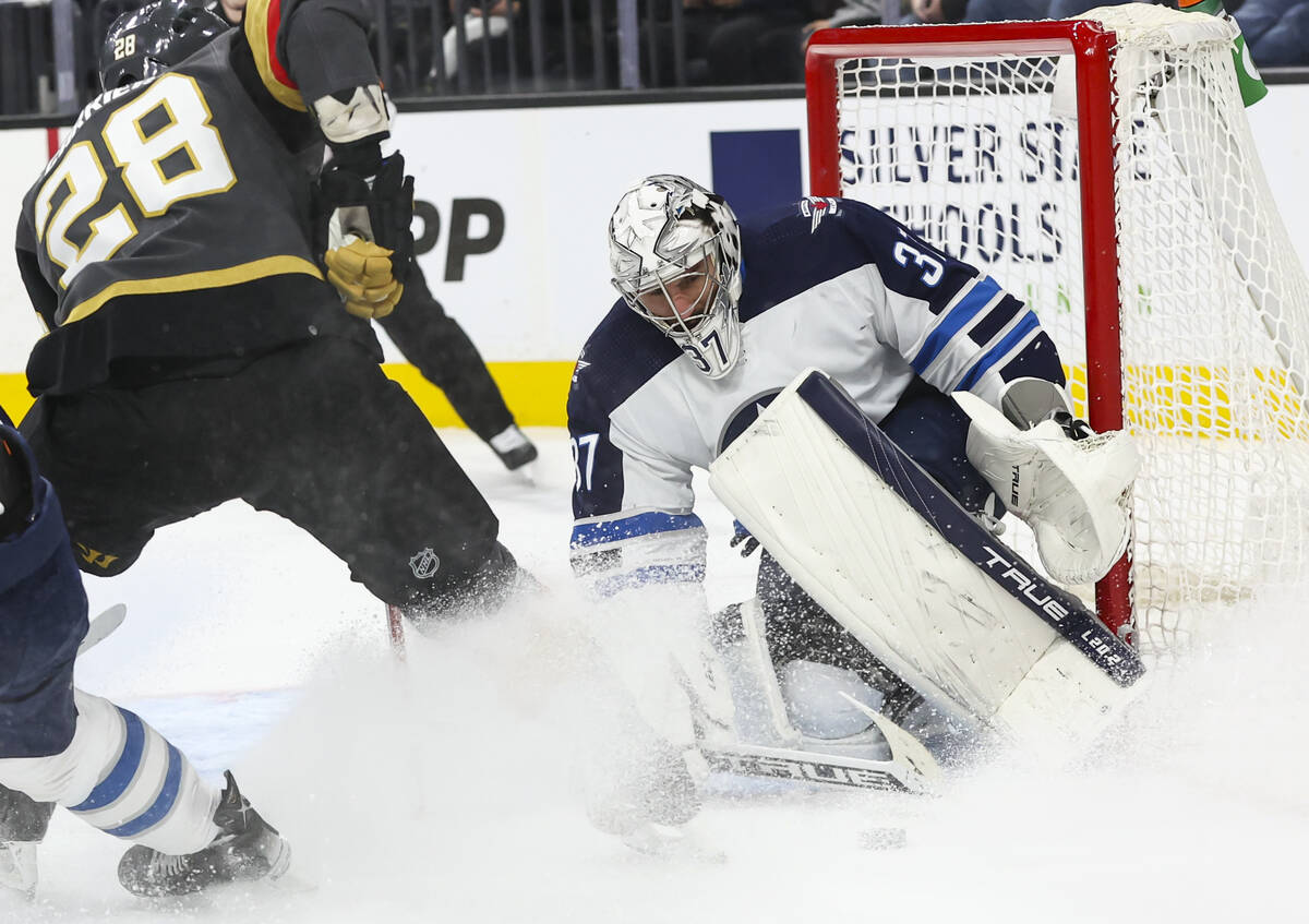 Winnipeg Jets goaltender Connor Hellebuyck (37) blocks the puck against Golden Knights left win ...