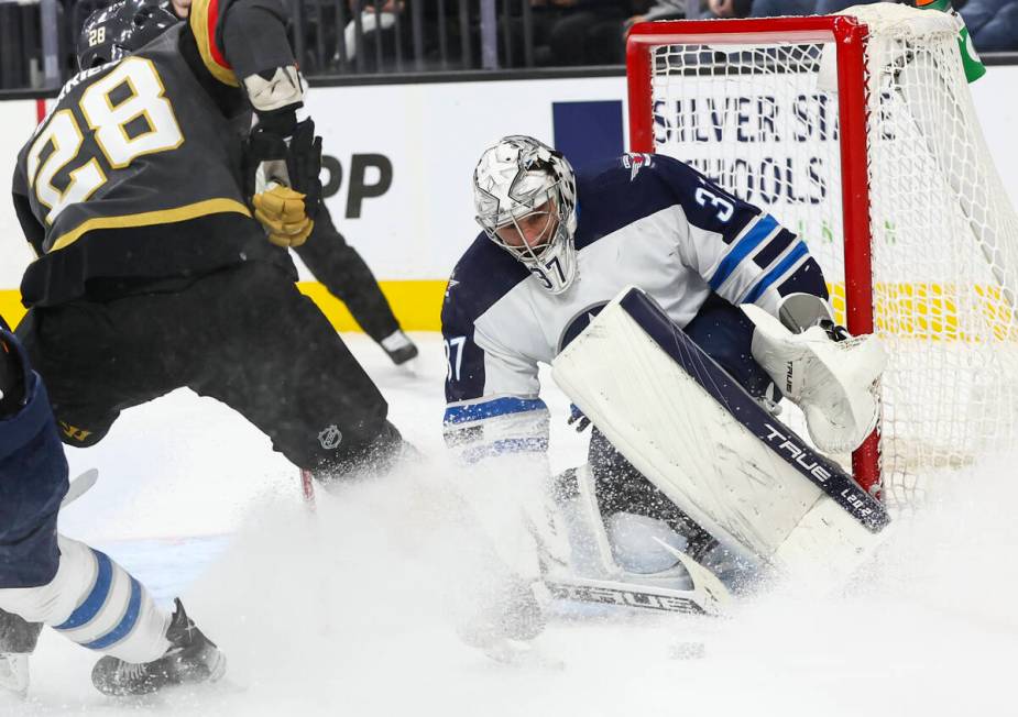 Winnipeg Jets goaltender Connor Hellebuyck (37) blocks the puck against Golden Knights left win ...