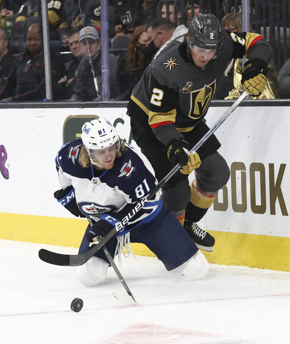 Golden Knights defenseman Zach Whitecloud (2) and Winnipeg Jets left wing Kyle Connor (81) batt ...