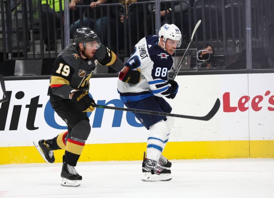 Winnipeg Jets defenseman Nate Schmidt (88) and Golden Knights right wing Reilly Smith (19) skat ...