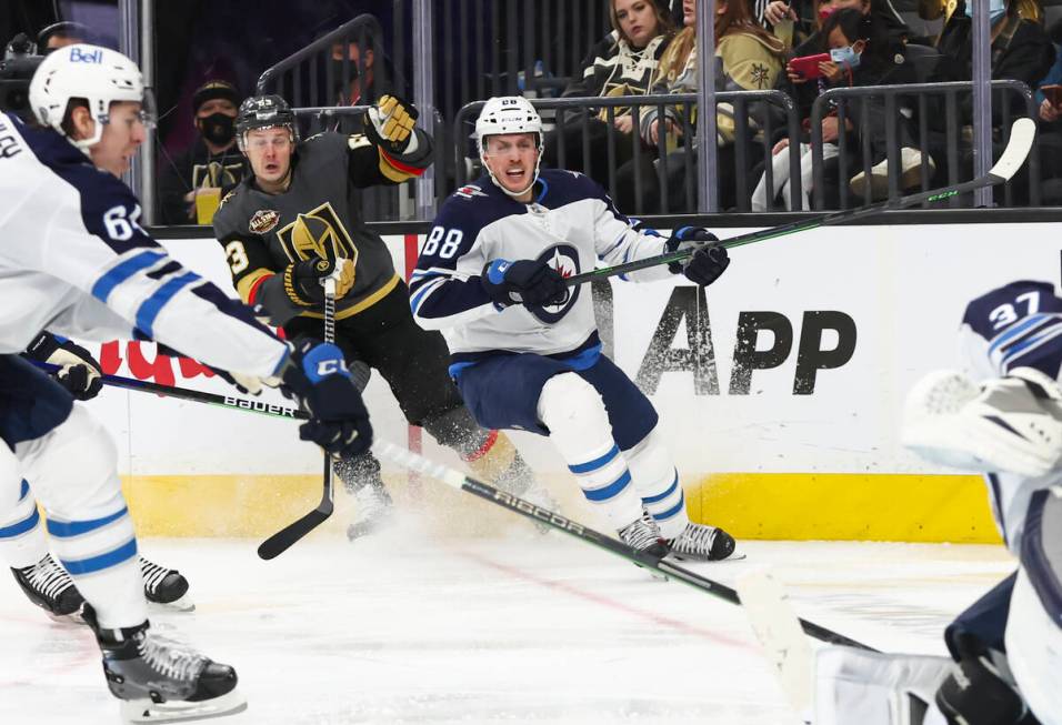 Golden Knights right wing Evgenii Dadonov (63) and Winnipeg Jets defenseman Nate Schmidt (88) w ...