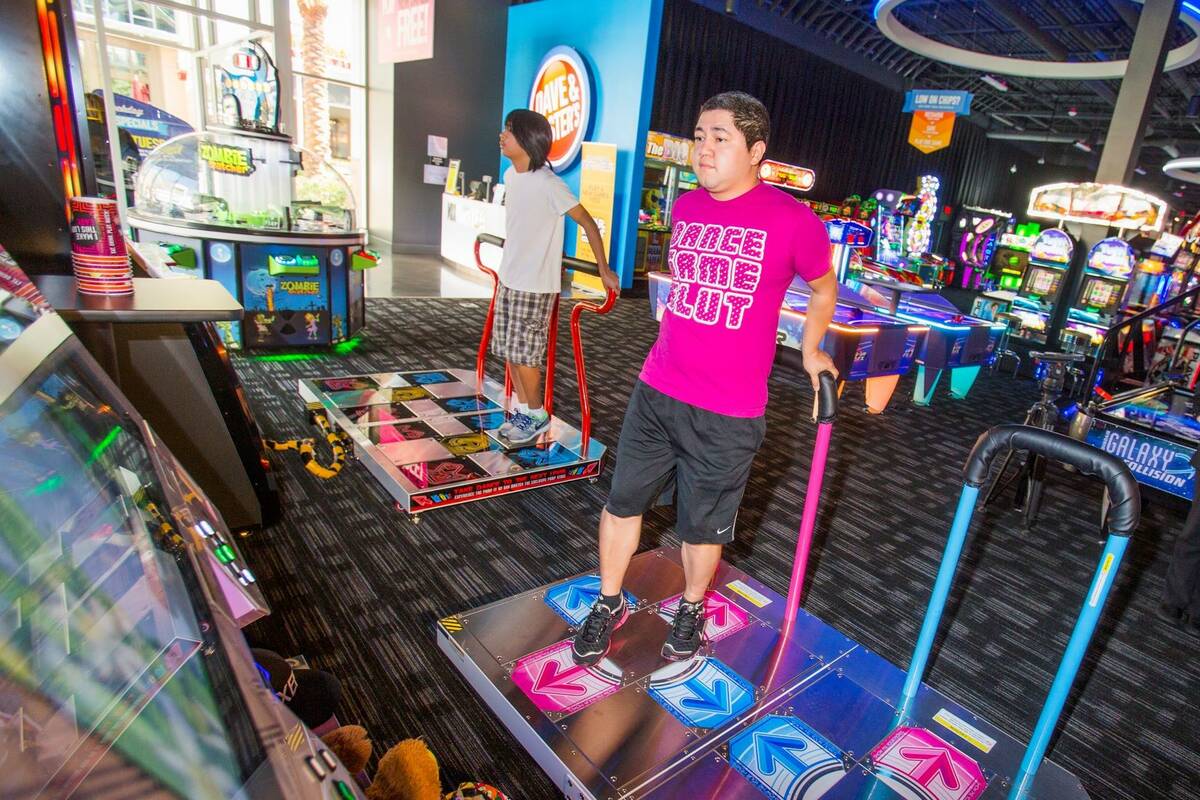Michael Alvarado plays the latest version of Dance Dance Revolution at Dave and Buster's in Dow ...