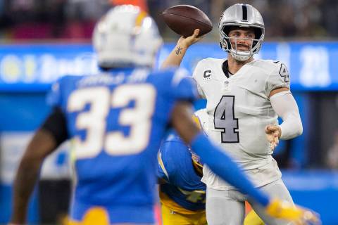 Raiders quarterback Derek Carr (4) makes a throw in traffic past Los Angeles Chargers free safe ...