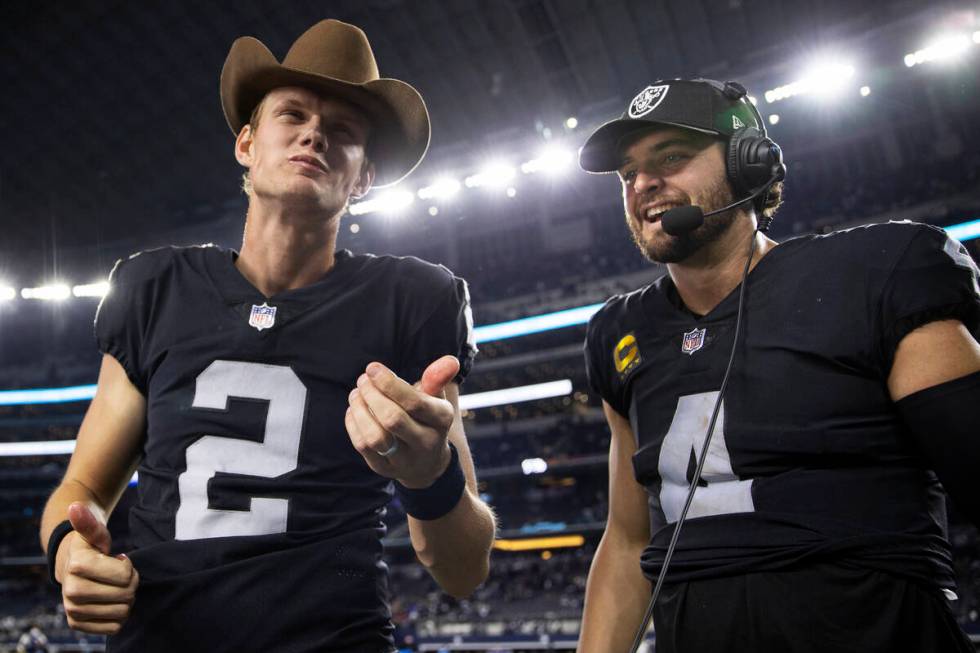 Raiders kicker Daniel Carlson (2) celebrates with Raiders quarterback Derek Carr (4) by eating ...