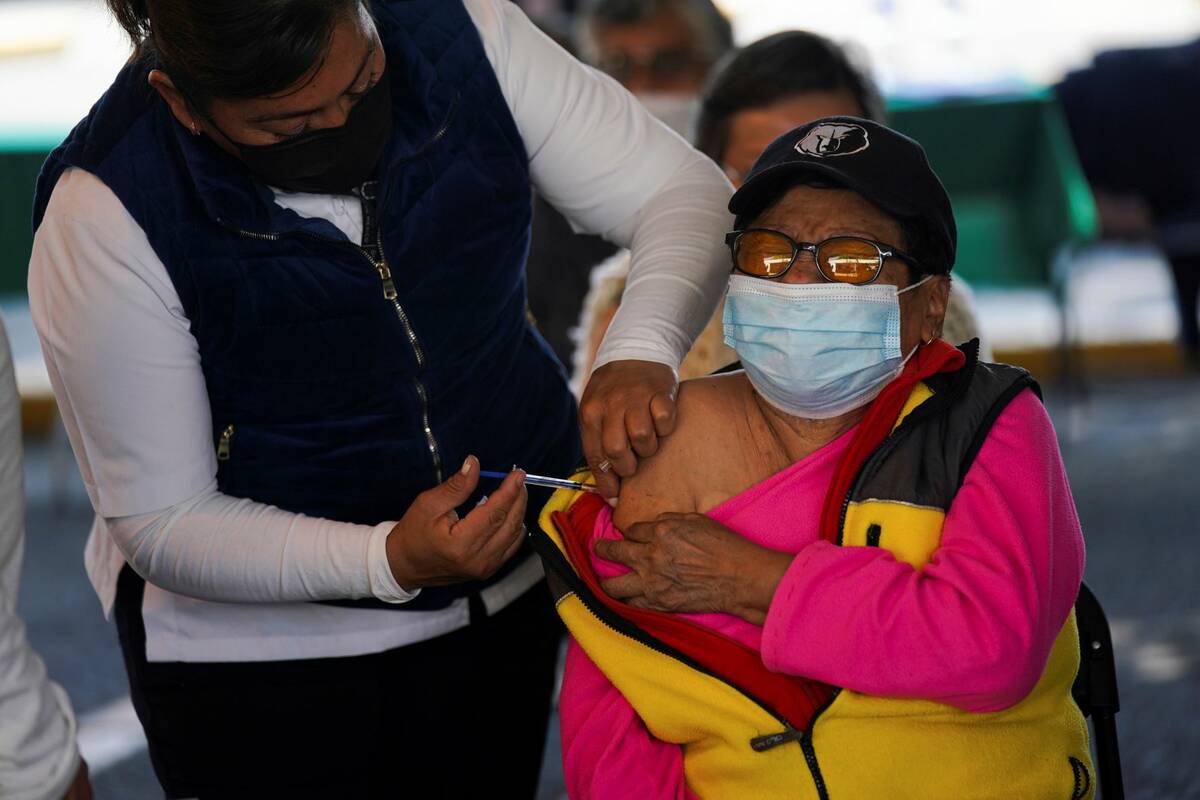 A woman receives a booster against COVID-19 during a vaccination campaign for people 60 and ove ...