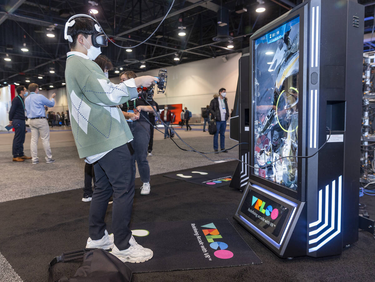 Attendee Kwanghyun Go plays a shooting game with the use of a VRLCO VR game system during the f ...
