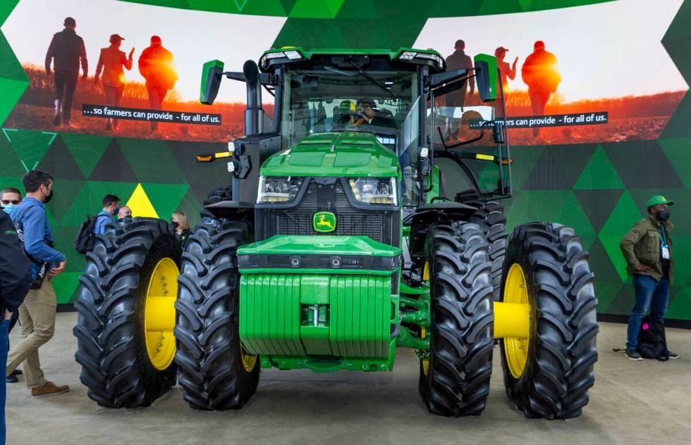Attendees check out a John Deere fully autonomous 8R tractor during the first day of CES at the ...