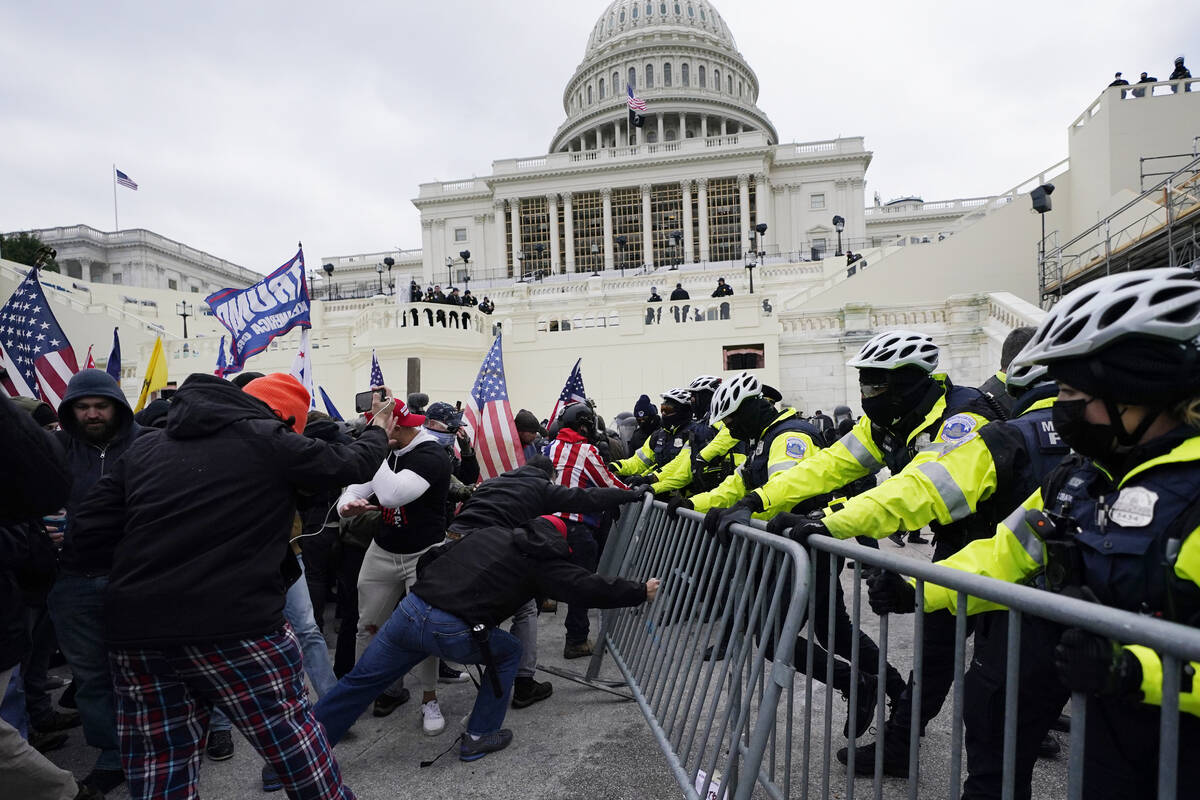 In this Wednesday, Jan. 6, 2021 file photo, Trump supporters try to break through a police barr ...