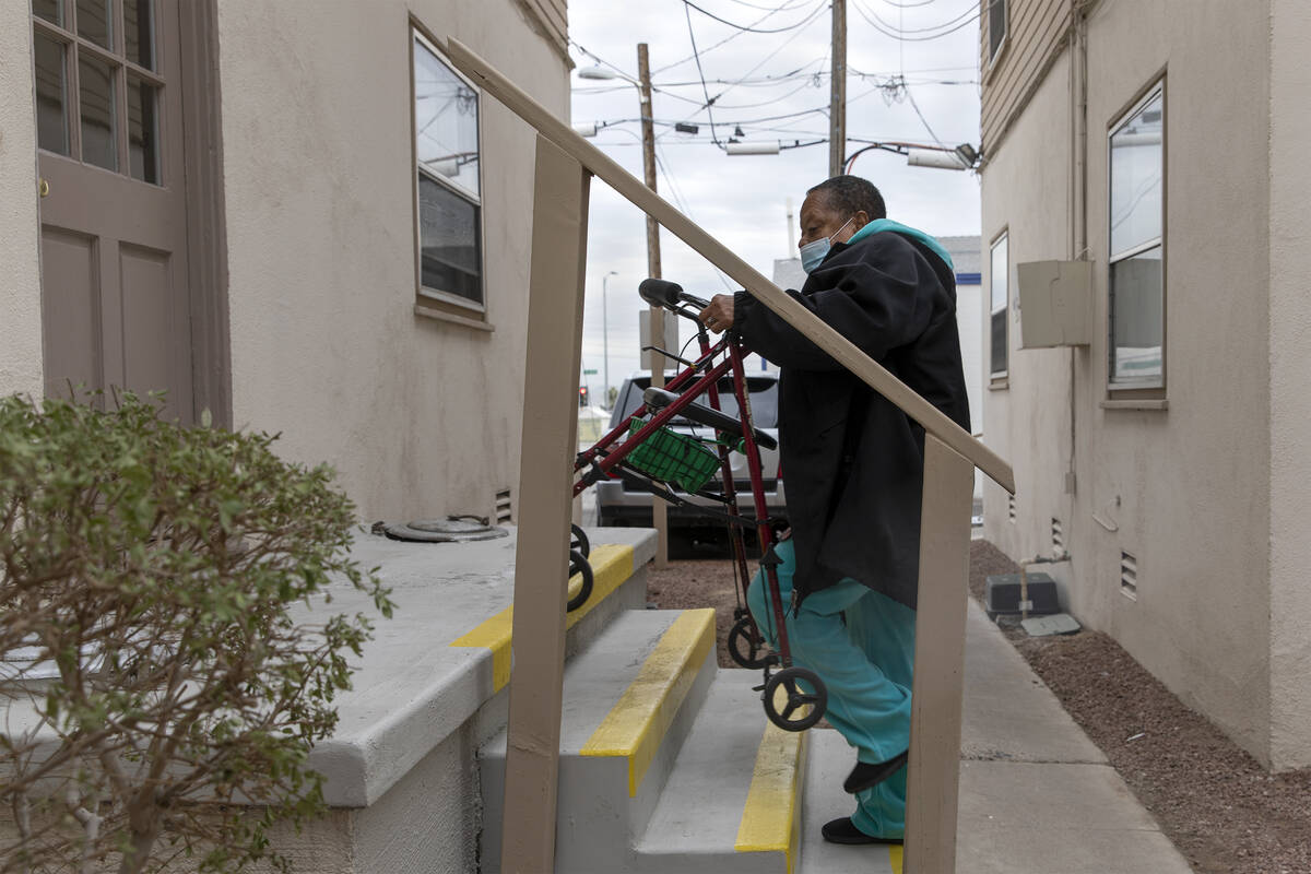 Esther Stokes, 74, brings her walker up the stairs to her unit at Desert Plaza Apartments on Tu ...