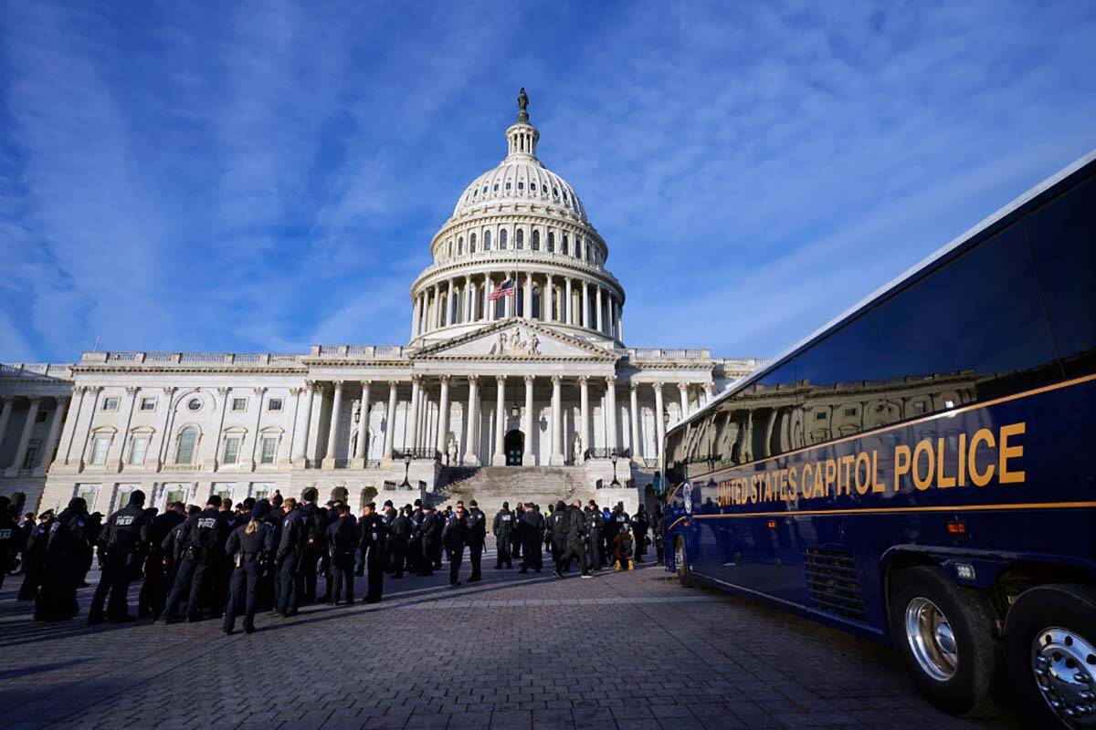 A large group of police arrive on a bus at the Capitol, Thursday, Jan. 6, 2022, in Washington. ...