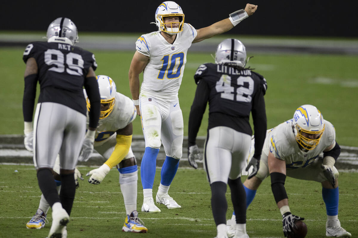 Los Angeles Chargers quarterback Justin Herbert (10) audibles in front of Raiders defensive end ...