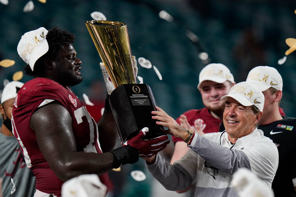 Alabama head coach Nick Saban and offensive lineman Alex Leatherwood hold the trophy after thei ...