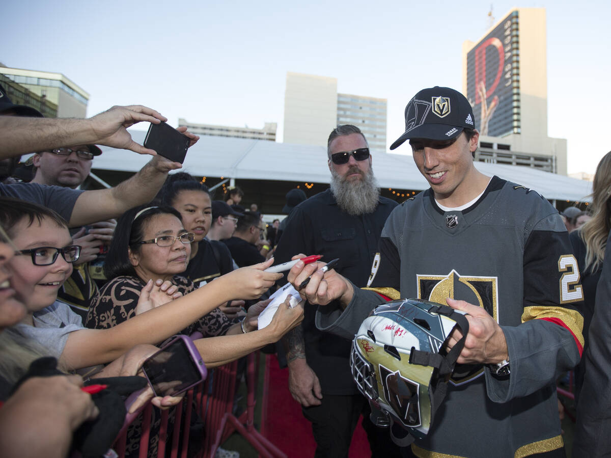 Vegas Golden Knights goaltender Marc-Andre Fleury (29), right, signs a helmet for Anthony Mora, ...