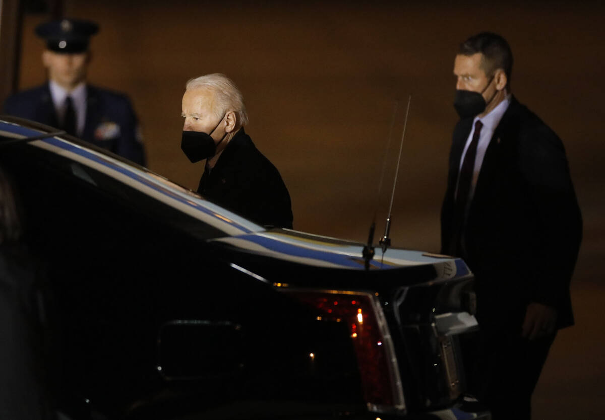 President Joe Biden, center, walks to a car after he arrived on Air Force One at Harry Reid Int ...