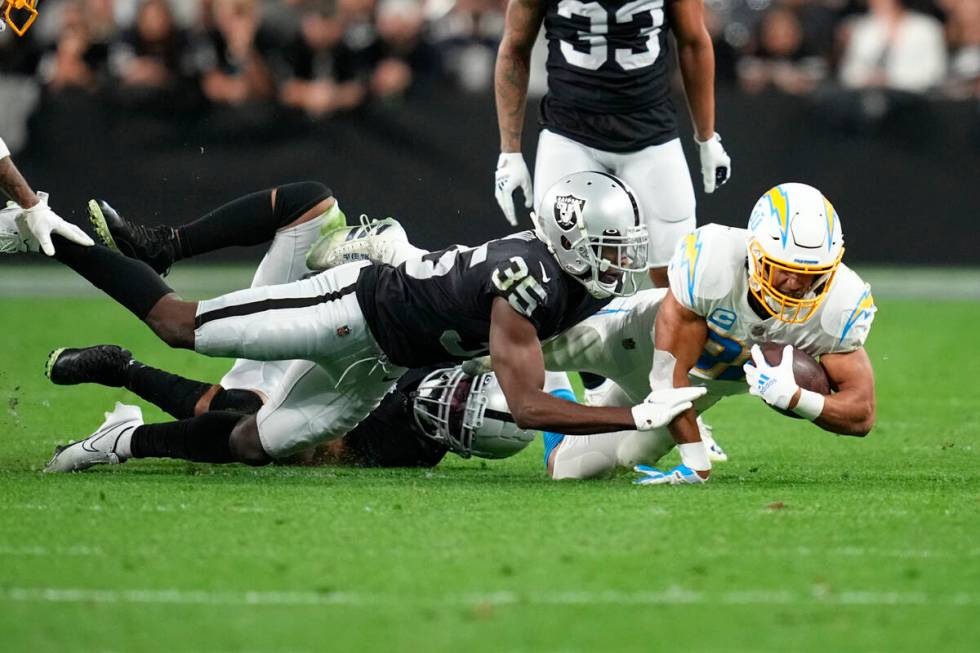 Los Angeles Chargers running back Austin Ekeler (30) is tackled after catching a deflected pass ...