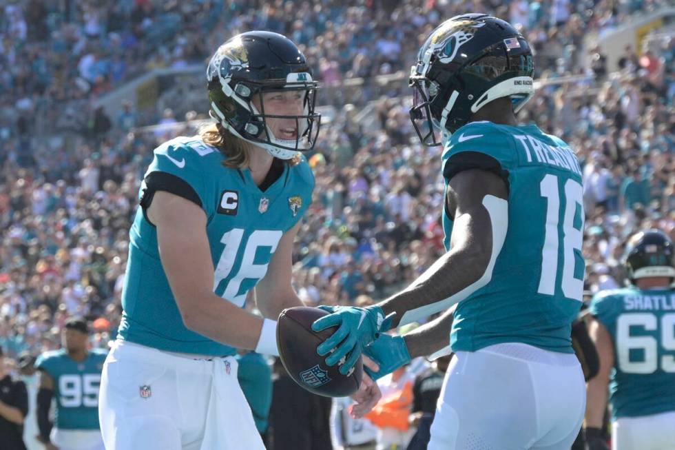 Jacksonville Jaguars quarterback Trevor Lawrence, left, and Jacksonville Jaguars wide receiver ...