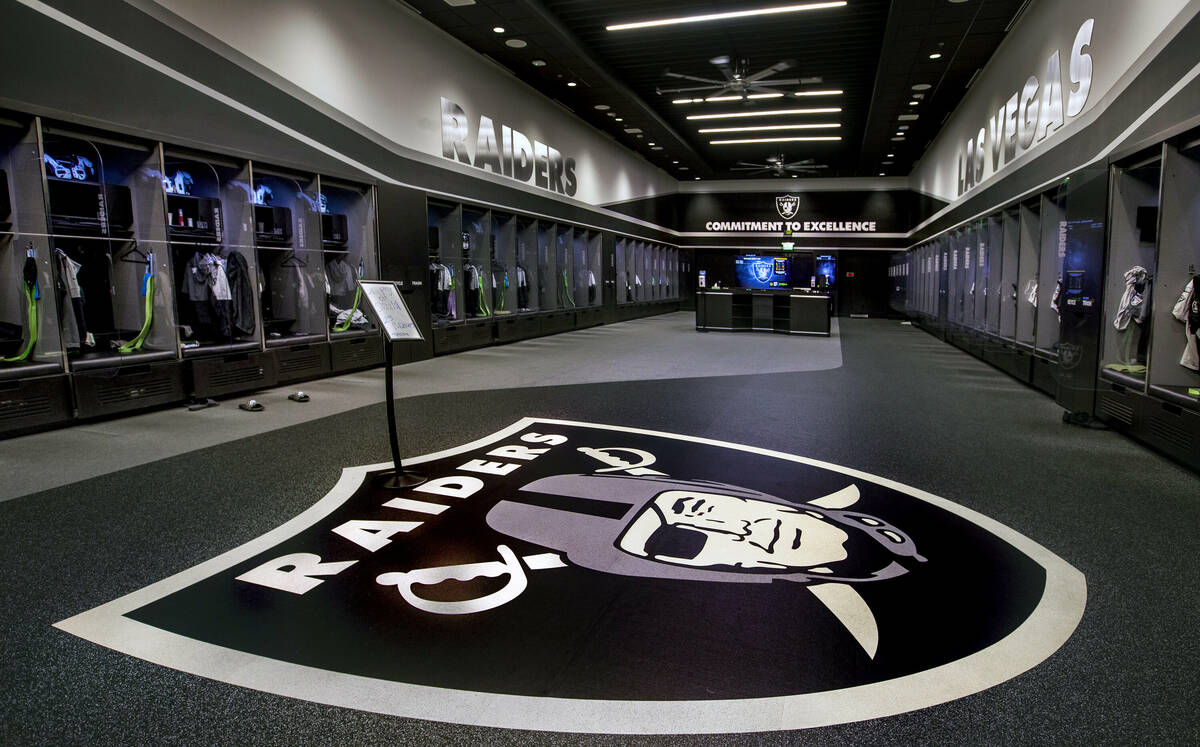 A large logo is painted on the floor in the expansive locker room within the Las Vegas Raiders ...