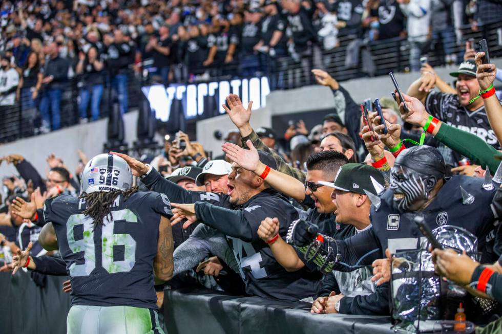 Raiders defensive tackle Darius Philon (96) celebrates a team interception with the fans versus ...