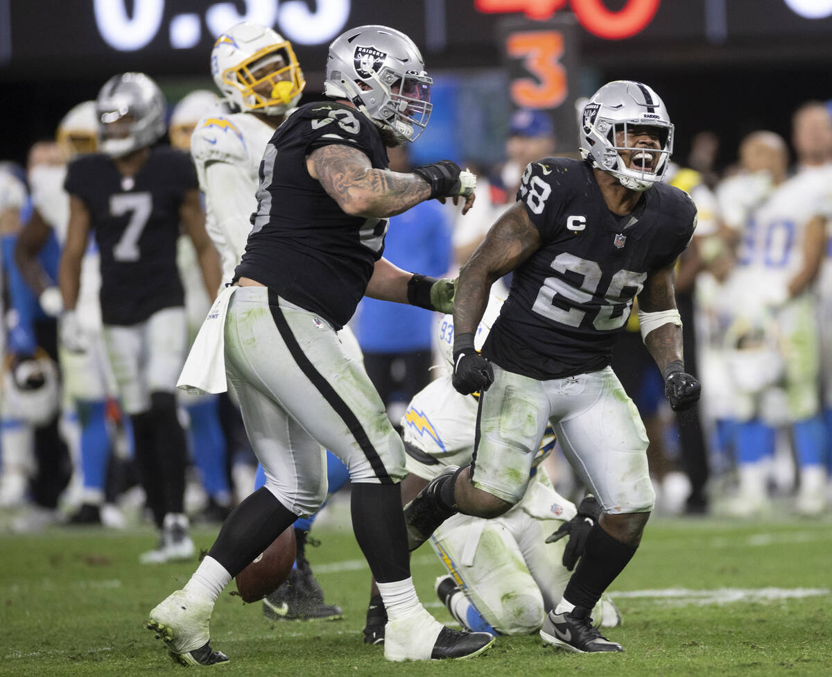 Raiders running back Josh Jacobs (28) celebrates after after making a big run in overtime duri ...