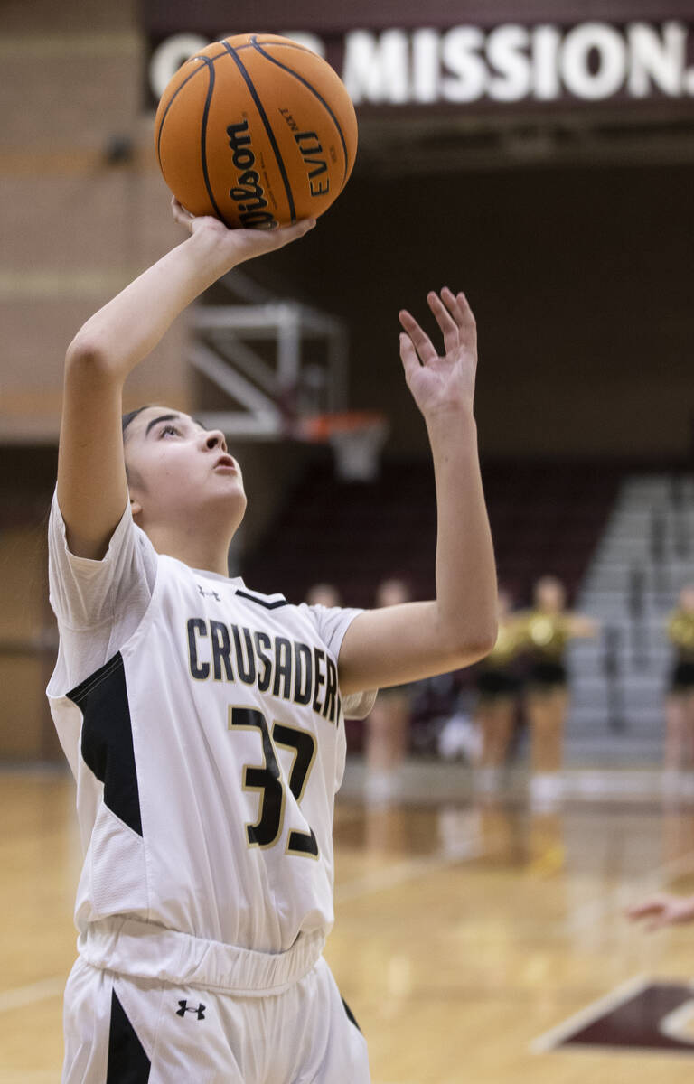 Faith Lutheran’s Emma Herpin (33) drives to the rim in the first quarter during a girls ...