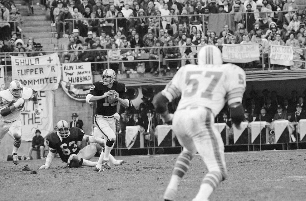 Ken Stabler, quarterback of the Oakland Raiders, looks downfield as he is pursued by Miami Dolp ...