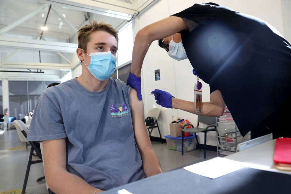 Grisly Guerrero gives a shot to Michael Camp, 17, at a COVID-19 vaccination station at Southern ...