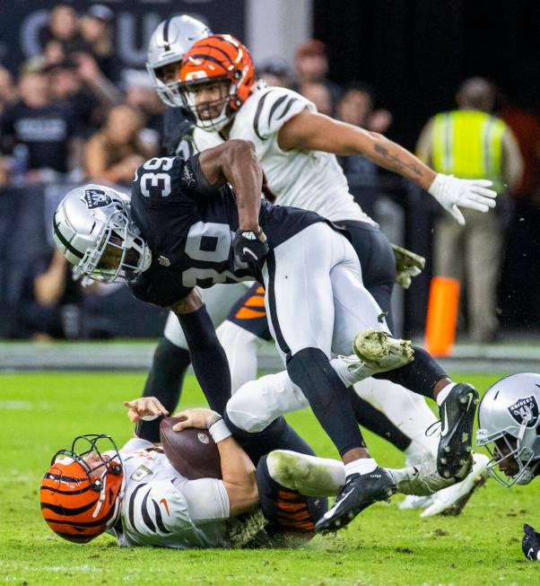 Cincinnati Bengals quarterback Joe Burrow (9) is taken down by Raiders cornerback Nate Hobbs (3 ...