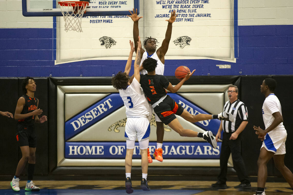Desert Pines’ Isiaac Boykin (3) and Greg Burrell (5) jump to block a shot by Mojave&#x20 ...