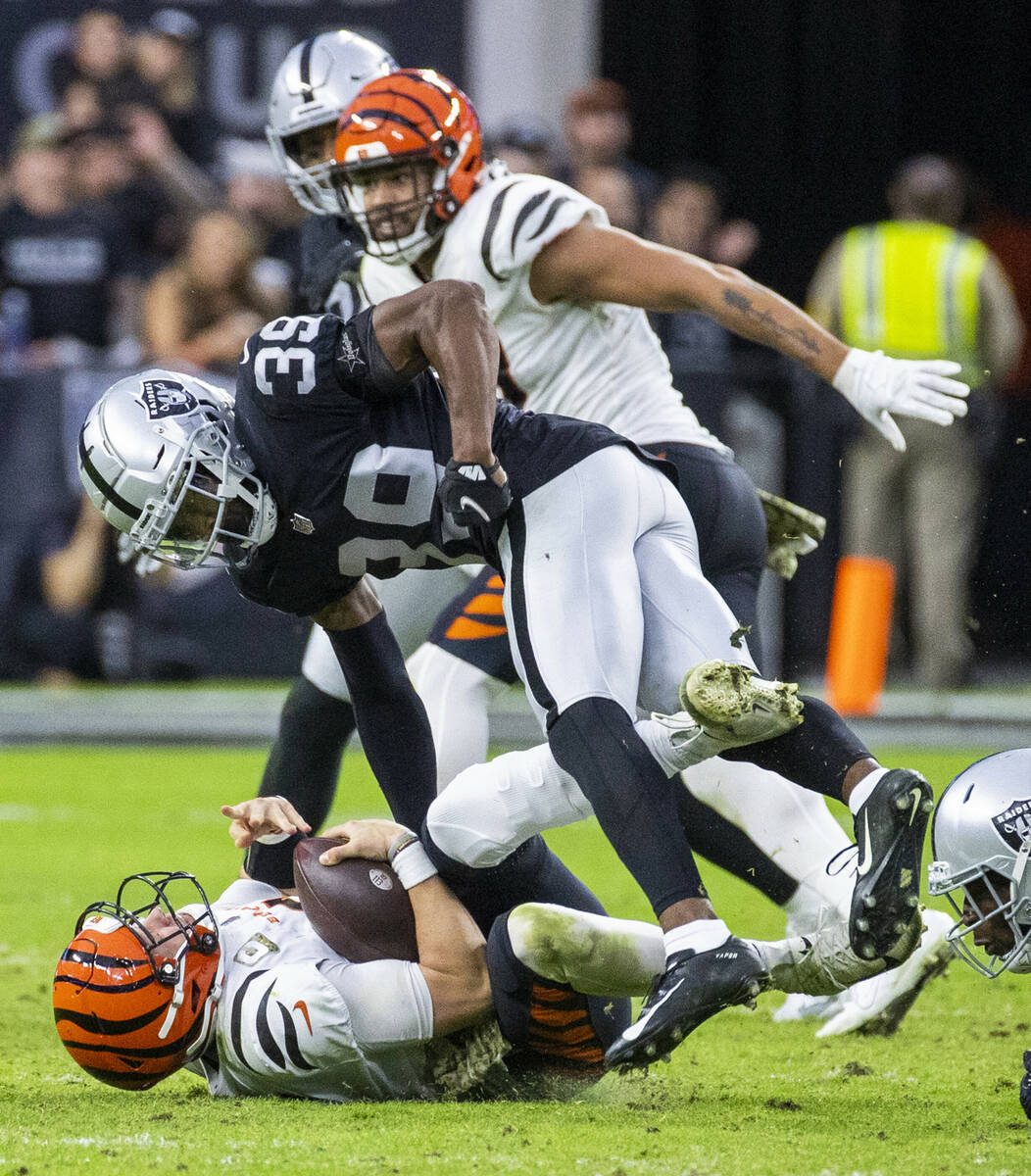 Cincinnati Bengals quarterback Joe Burrow (9) is taken down by Raiders cornerback Nate Hobbs (3 ...