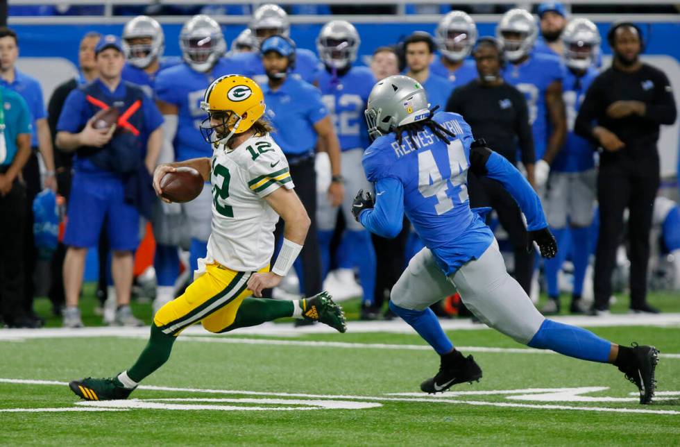 Green Bay Packers quarterback Aaron Rodgers (12) is pursued by Detroit Lions inside linebacker ...
