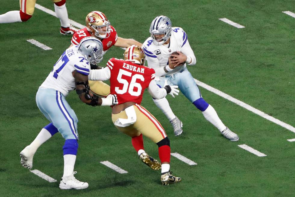Dallas Cowboys quarterback Dak Prescott, right, is pressured by San Francisco 49ers defensive e ...