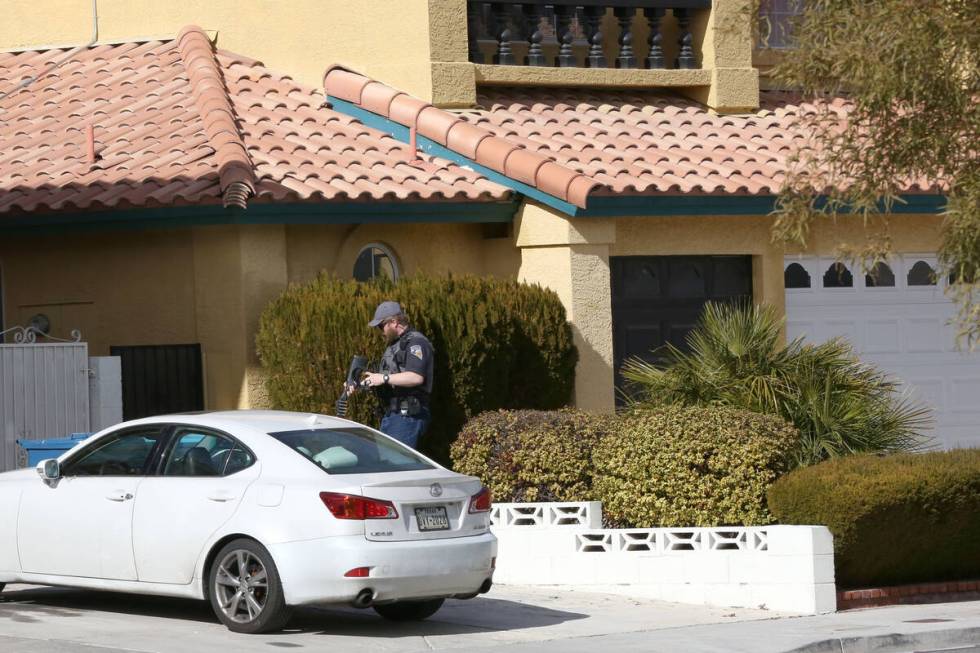 An officer from the Nevada Department of Wildlife prepares to enter the backyard of a residence ...