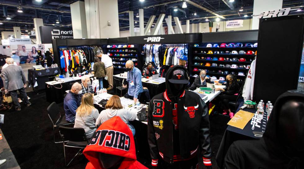 Attendees chat with representatives at the Pro Standard booth during the Sports Licensing & ...