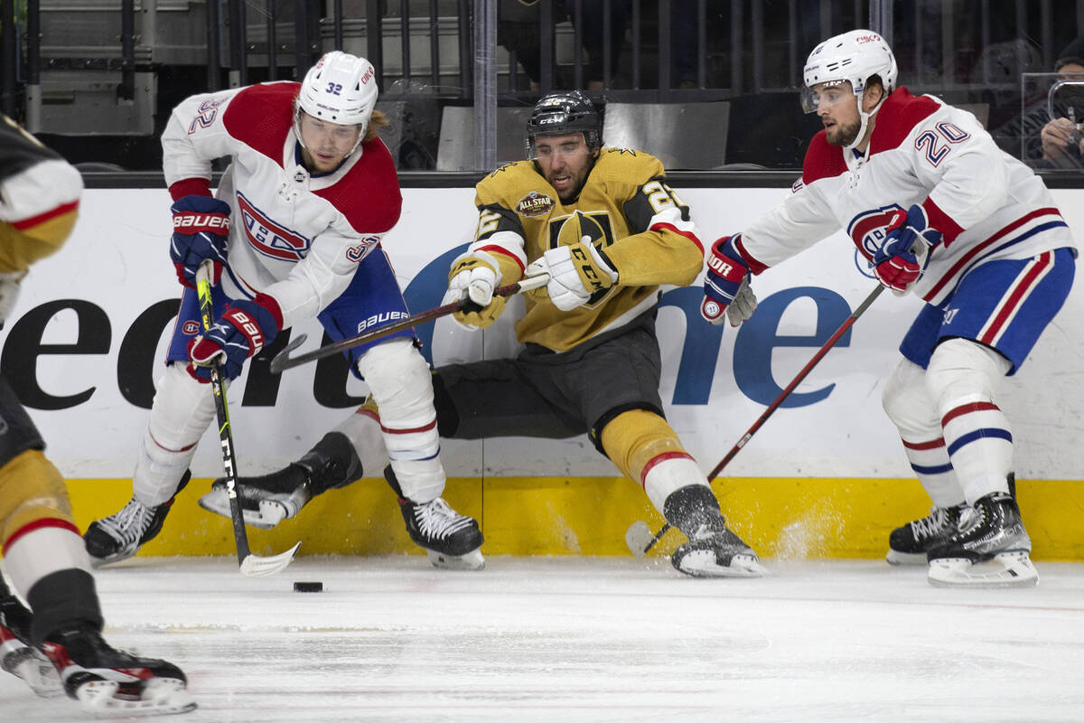 Golden Knights center Michael Amadio (22) falls while competing for the puck with Canadiens cen ...