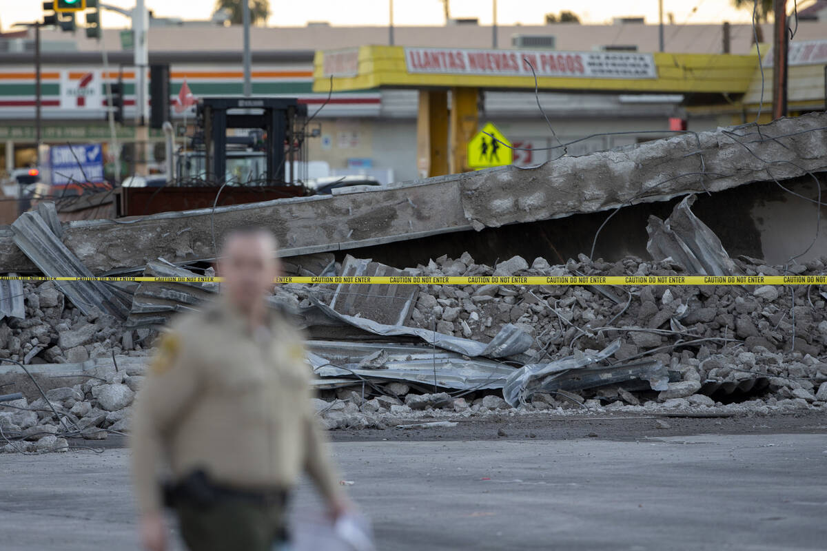 A Las Vegas police officer responds to the scene where a portion of a bridge collapsed at U.S. ...